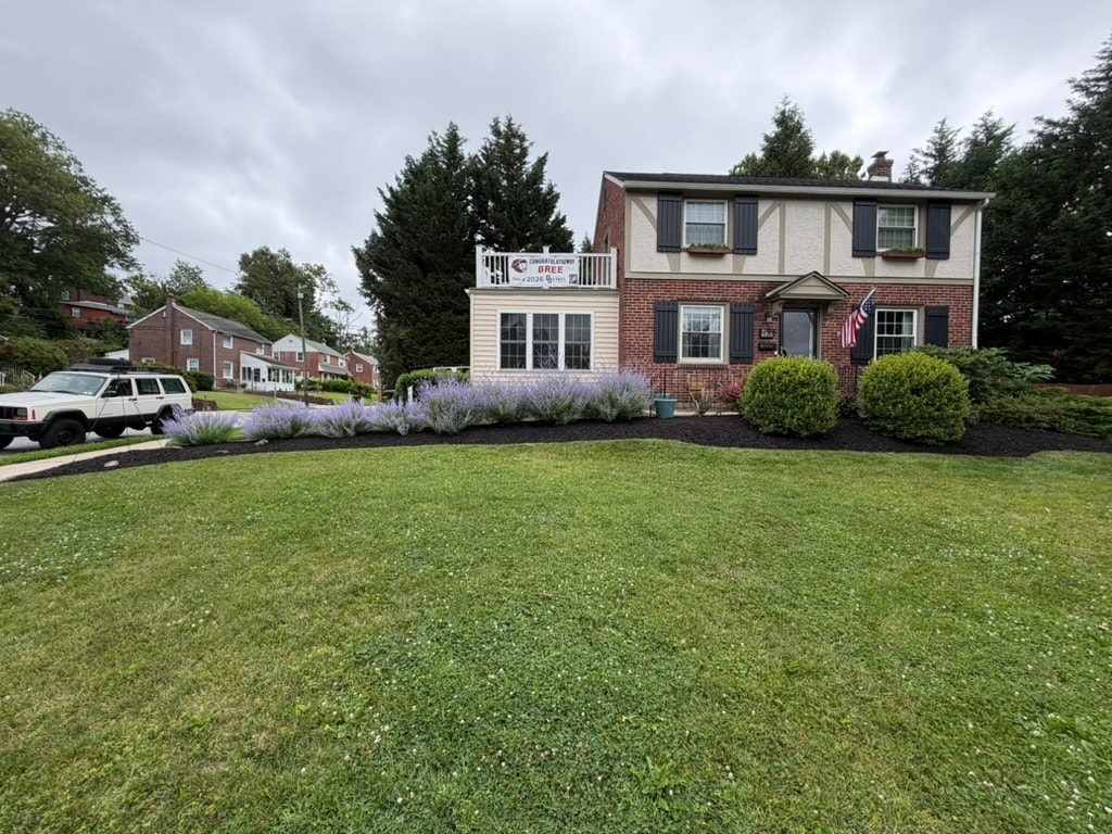 Residential front yard with a new planting bed and mulch installed along the home's foundation